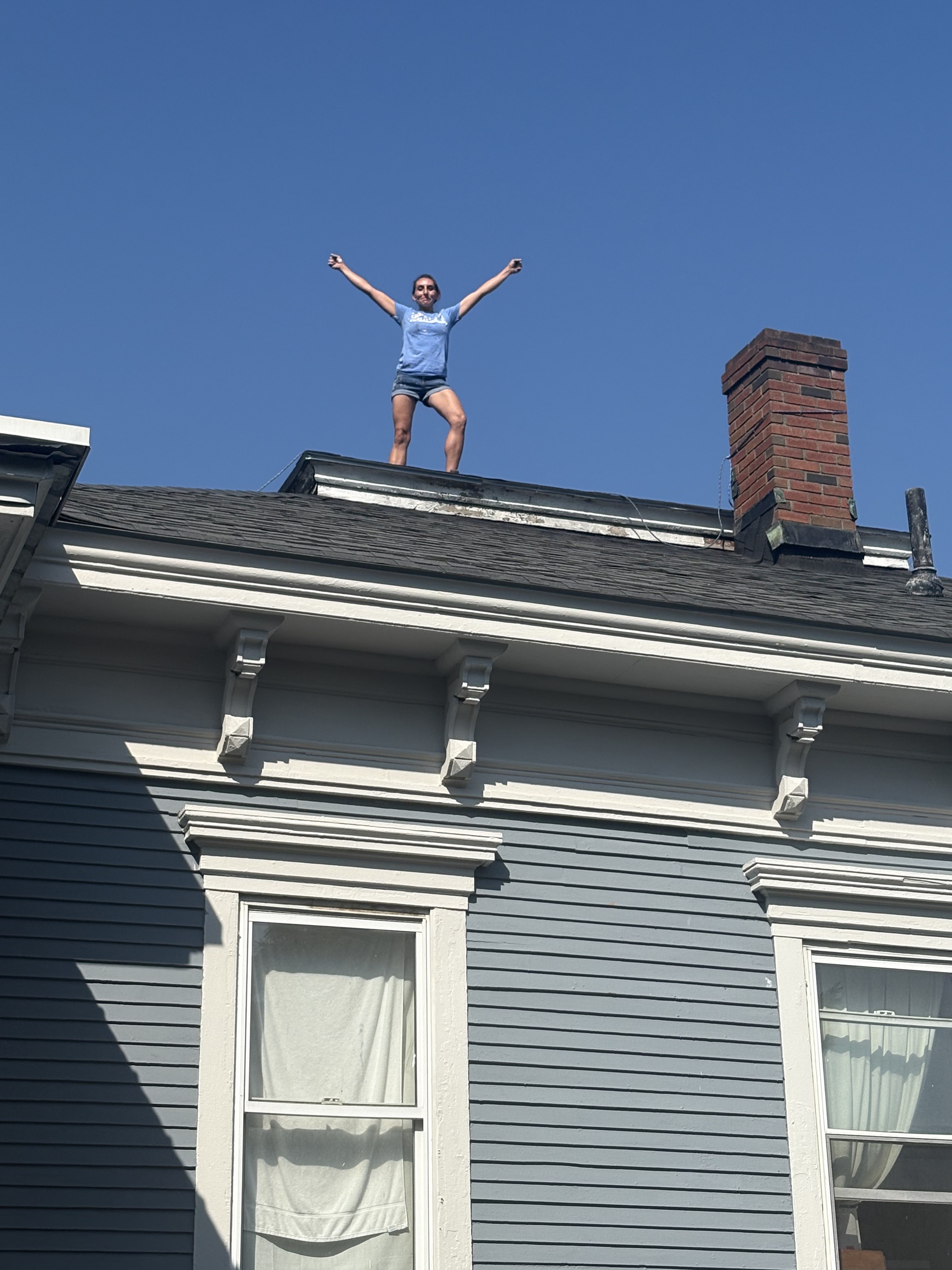 Morgana standing on a rooftop with her arms raised