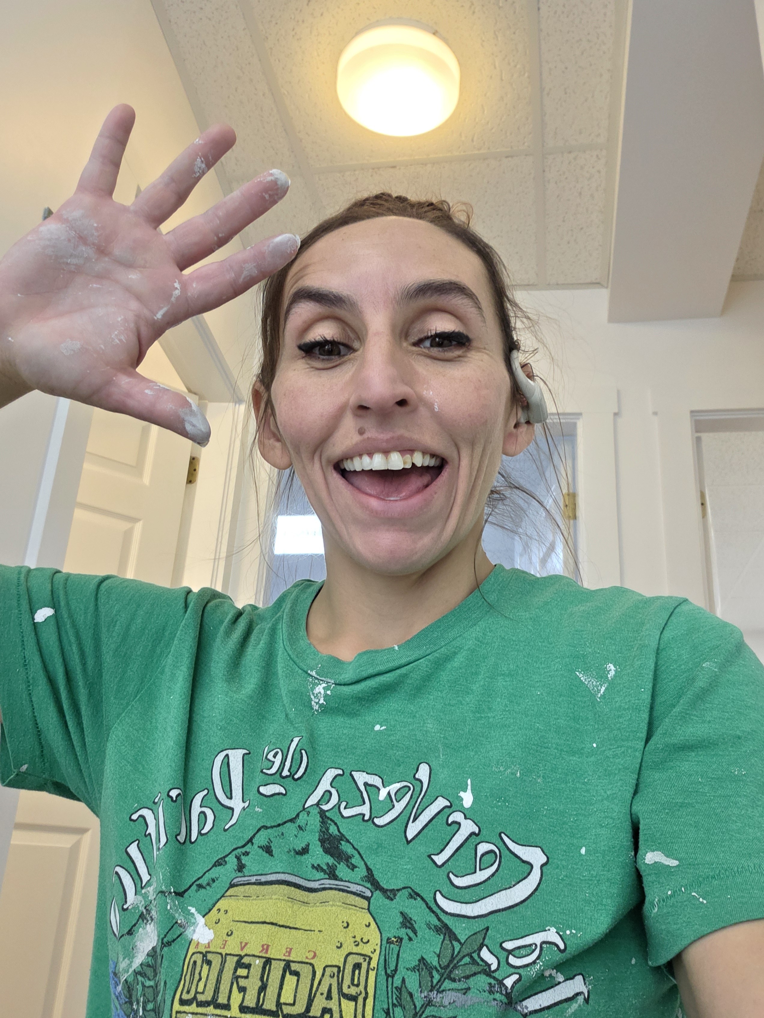 Morgana smiling with paint on her hands after a day of work